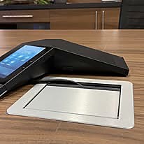 Téléphone de conférence intégré à une table de réunion